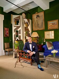 a man in a tuxedo sitting on a chair