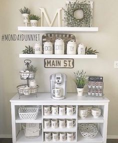 a white shelf with coffee cups and mugs on it in front of a sign that says main st