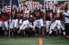 a group of football players standing on top of a field