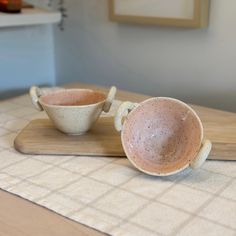 two cups sitting on top of a wooden tray