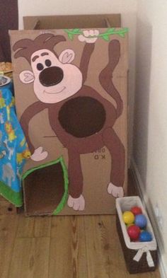 there is a cardboard box with a monkey on it and some toys in the corner