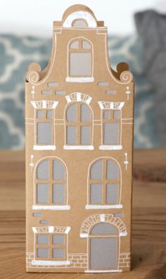 a cardboard doll house with windows and doors