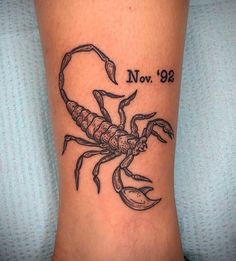 a small scorpion tattoo on the side of a woman's leg that says no 98