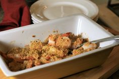 a white bowl filled with food on top of a wooden table