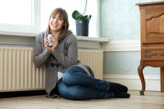 a woman sitting on the floor holding a camera