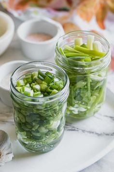 two mason jars filled with green beans and onions