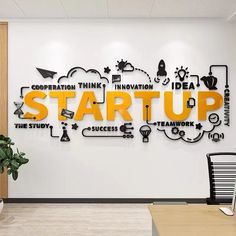 an office wall with the words start up written on it in bright yellow and black