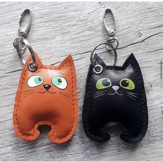 two leather key chains with cats on them