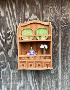 a wooden shelf with two green glass plates on it and a teapot in the middle