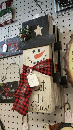 a snowman is hanging on the wall next to other christmas decorations and signs in a store