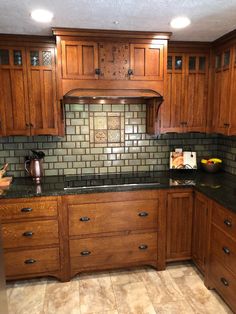 a kitchen with wooden cabinets and granite counter tops, along with tile backsplash