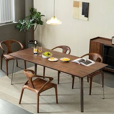 a dining room table with chairs and a television set in the corner next to it