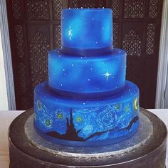 a three tiered blue cake with stars on it