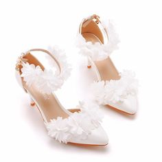 white wedding shoes with flowers on the heel