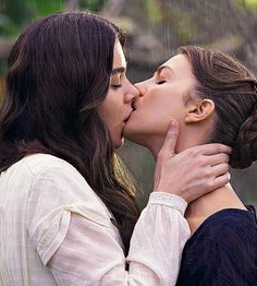 two women kissing each other in the rain