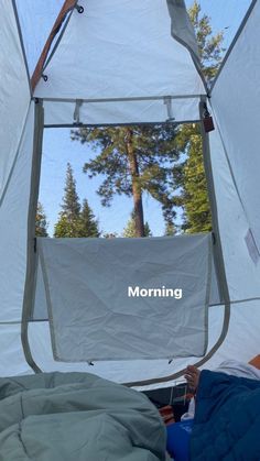 the inside of a tent with trees reflected in it's glass window and text reading morning