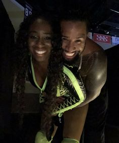 a man and woman posing for a photo in front of a camera with their arms around each other