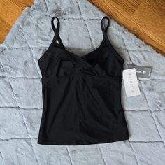 This Black Twister Tankini Made By Athleta Is New With Tags! Perfect If You Prefer Some Extra Coverage While Swimming At The Beach Or Pool This Summer. Does Not Have The Removable Pads In The Bust, They Are Missing. Women's Size 34 B/C. Flat Lay Measurements Approximately 14 Inches Pit To Pit And 14.5 Inches In Length. The Shoulder Straps Are Adjustable. Please See Photos For Additional Measurements, Make Of Fabric And Care Instructions. Measurements Are Approximate, Please See Photos. Color Is Black Stretch Sporty Tankini, Fitted Black Sports Tankini, Sporty Black Tankini For Sports, Black Sleeveless Tankini In Athleisure Style, Black Stretch Athleisure Tankini, Black Athleisure Stretch Tankini, Black Sleeveless Athleisure Tankini, Sporty Black Tank Top For Swimming, Casual Black Sports Tankini