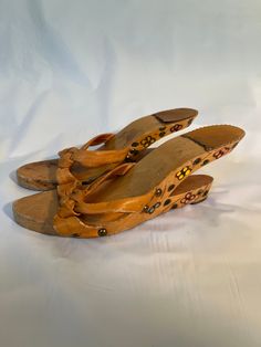 Vintage unusual wooden slides with open heel.  Flowers decorate the wood.  Leather upper shows some wear as well as the sole. Vintage Open Toe Sandals For The Beach, Wooden Open Toe Heels For Spring, Spring Vintage High Heel Clogs, Spring Open Toe Wooden Heels, Wooden Sandals With Wooden Heel For Summer, Wooden Heel Sandals For Summer, Vintage Summer Mules With Wooden Heel, Vintage Mules With Wooden Heel For Summer, Vintage Open Toe Mules With Wooden Heel