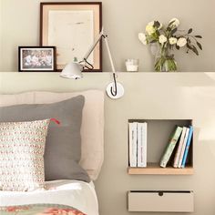 a bedroom with a bed, bookshelf and flowers on the wall above it