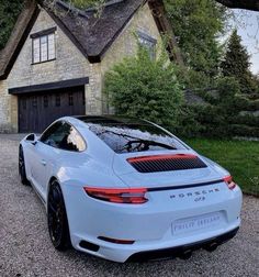 a white porsche parked in front of a house