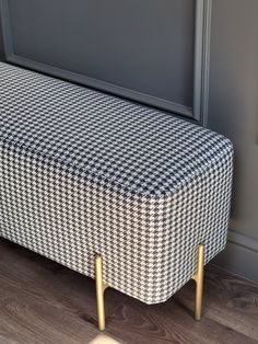 a black and white checkered bench with gold legs