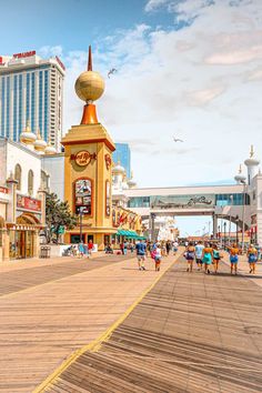 people walking on the boardwalk in front of buildings