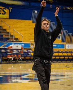 a man is throwing a frisbee in the air while standing on a basketball court