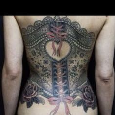 the back of a woman's body with tattoos and ribbons on her stomach,