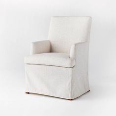 an upholstered white chair on a white background