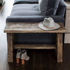 a couch with a hat and booties sitting on it's end table in a living room