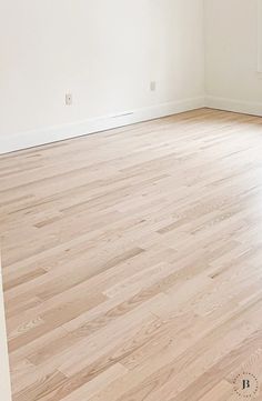 an empty room with hard wood floors and white walls