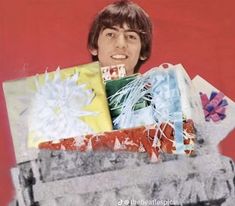 a young man is holding some presents in his hands