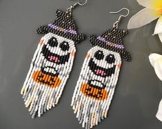 the beaded earrings are decorated with black and white beads, which have an image of a witch on it