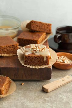 slices of carrot cake with frosting and nuts on wooden cutting board next to bowl of oatmeal