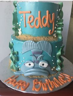 a three tiered birthday cake decorated with an image of a fish and the words teddy on it