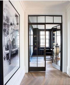 an instagramted photo of a black and white hallway with pictures on the wall