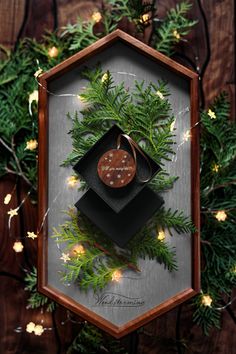 a christmas ornament hanging from a wooden frame on top of a tree branch