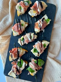 small appetizers are arranged on a black tray