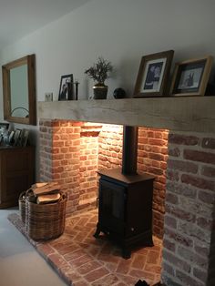 a fire place sitting in the middle of a living room next to a brick wall