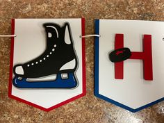 two paper cutouts depicting skates and the letter h