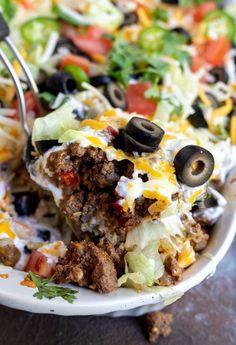 a close up of a plate of taco salad with a fork in the bowl