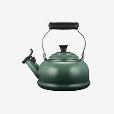 a green tea kettle with a black handle