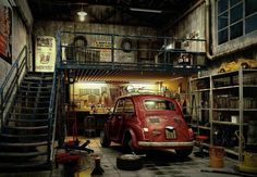 an old red car parked in a garage with stairs leading up to the second floor