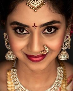 a woman with makeup and jewelry on her face