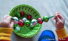 a child is playing with an ornament in a basket