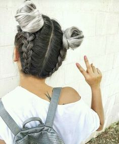 a woman with grey hair is holding her hand up in the air while wearing a backpack