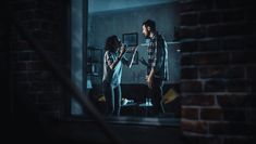 a man and woman standing in front of a mirror