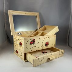 two wooden boxes with ladybugs painted on the sides and one has a mirror in it