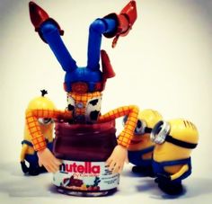 two toy minion figures sitting next to each other in front of a nutella container